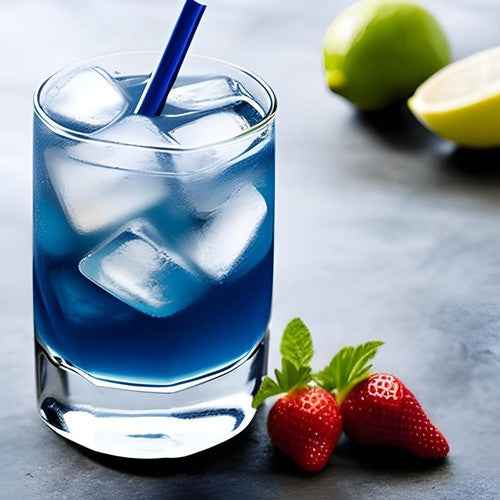 Glass of iced butterfly pea flower tea caffeine free with fresh strawberries and lime on the side