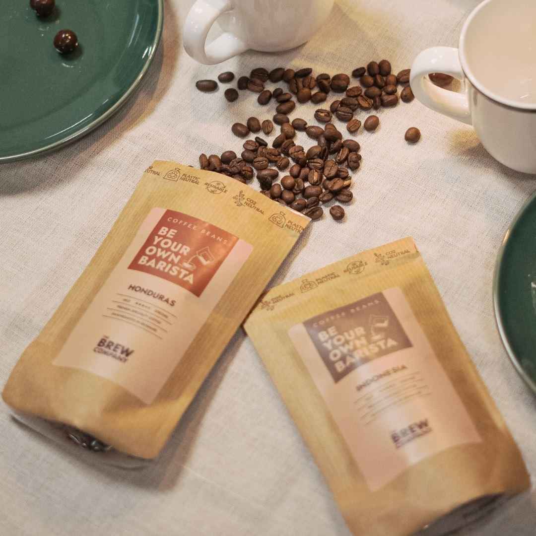 The Brew Company premium coffee gift set featuring Honduras coffee beans with cups and plates on table