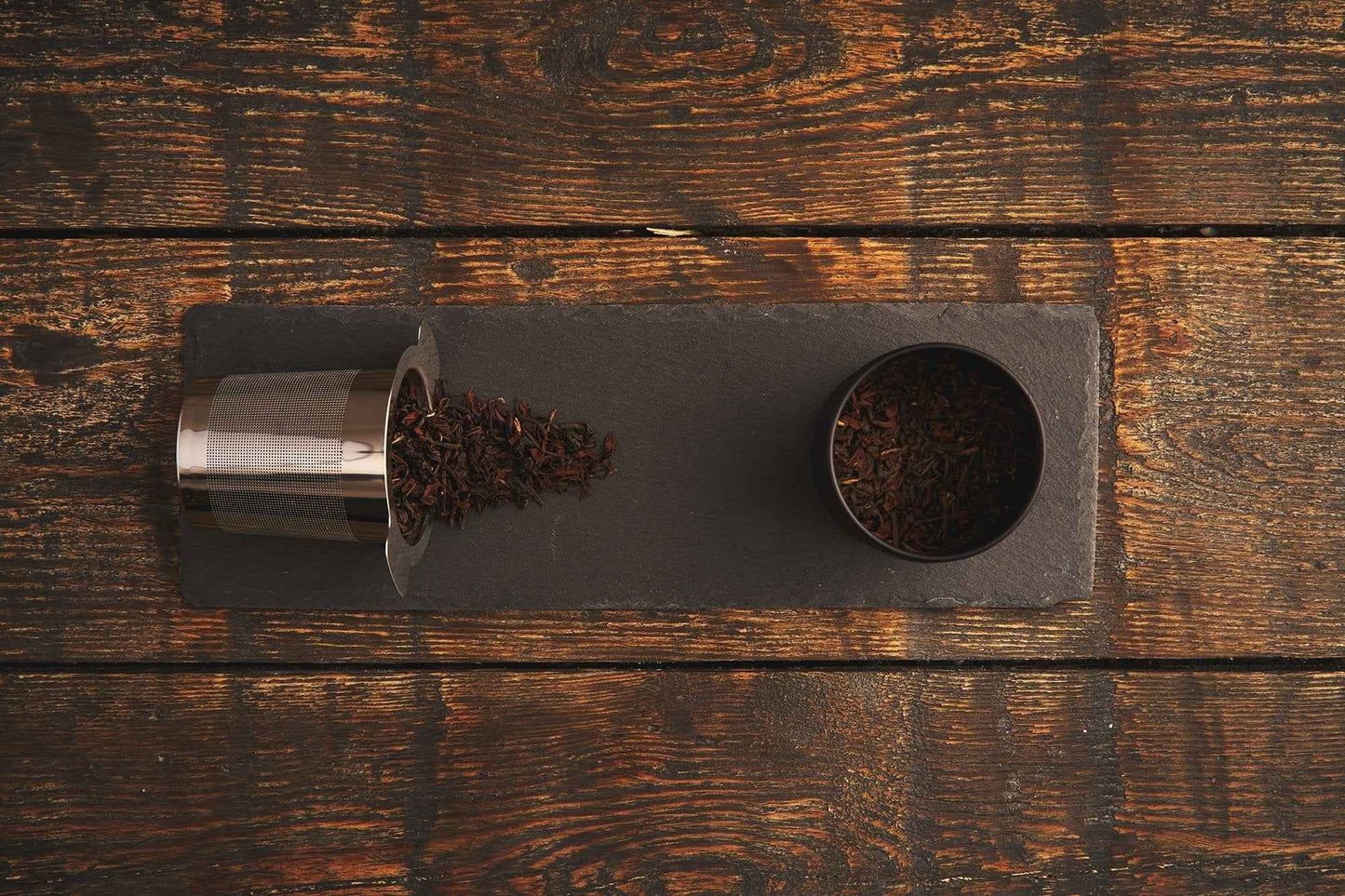 B.TEALY handcrafted tea filter with loose tea leaves displayed on a rustic wooden table