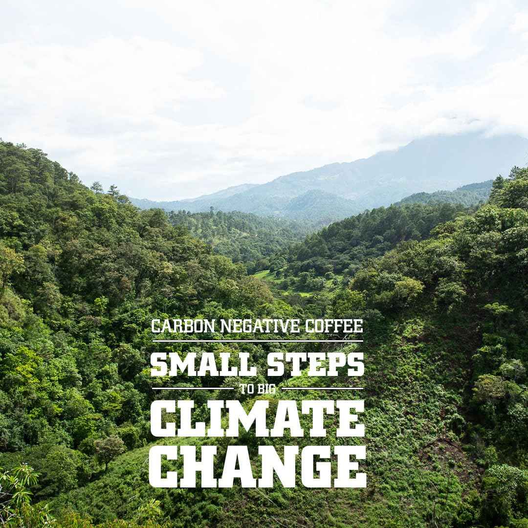 Green forested mountain landscape with text promoting fair trade organic coffee beans and climate change awareness