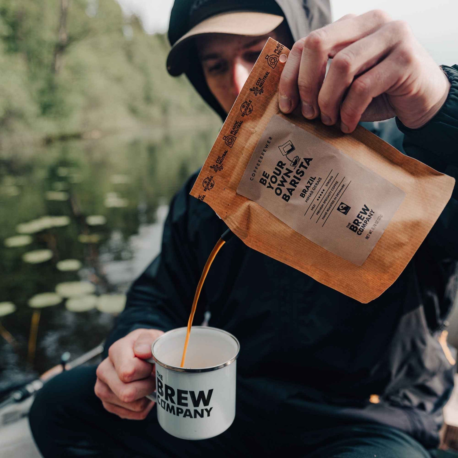 The Brew Company premium decaf coffee gift box with coffee being poured into a branded mug outdoors