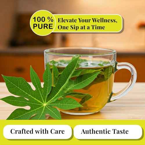 Glass cup of organic papaya leaf tea with fresh green papaya leaves highlighting pure herbal tea