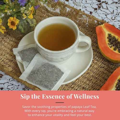 Cup of organic papaya leaf tea with tea bags and fresh papaya on a woven mat next to flowers