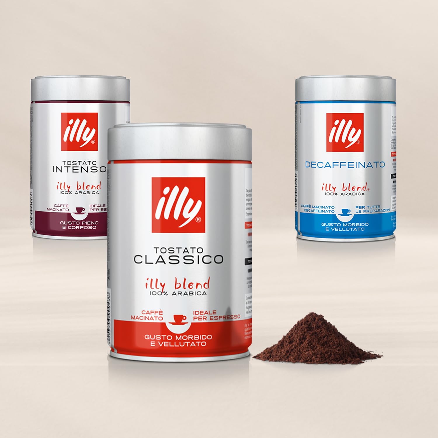 Illy ground espresso coffee tins in Classico, Intenso and Decaffeinato blends with a pile of ground coffee